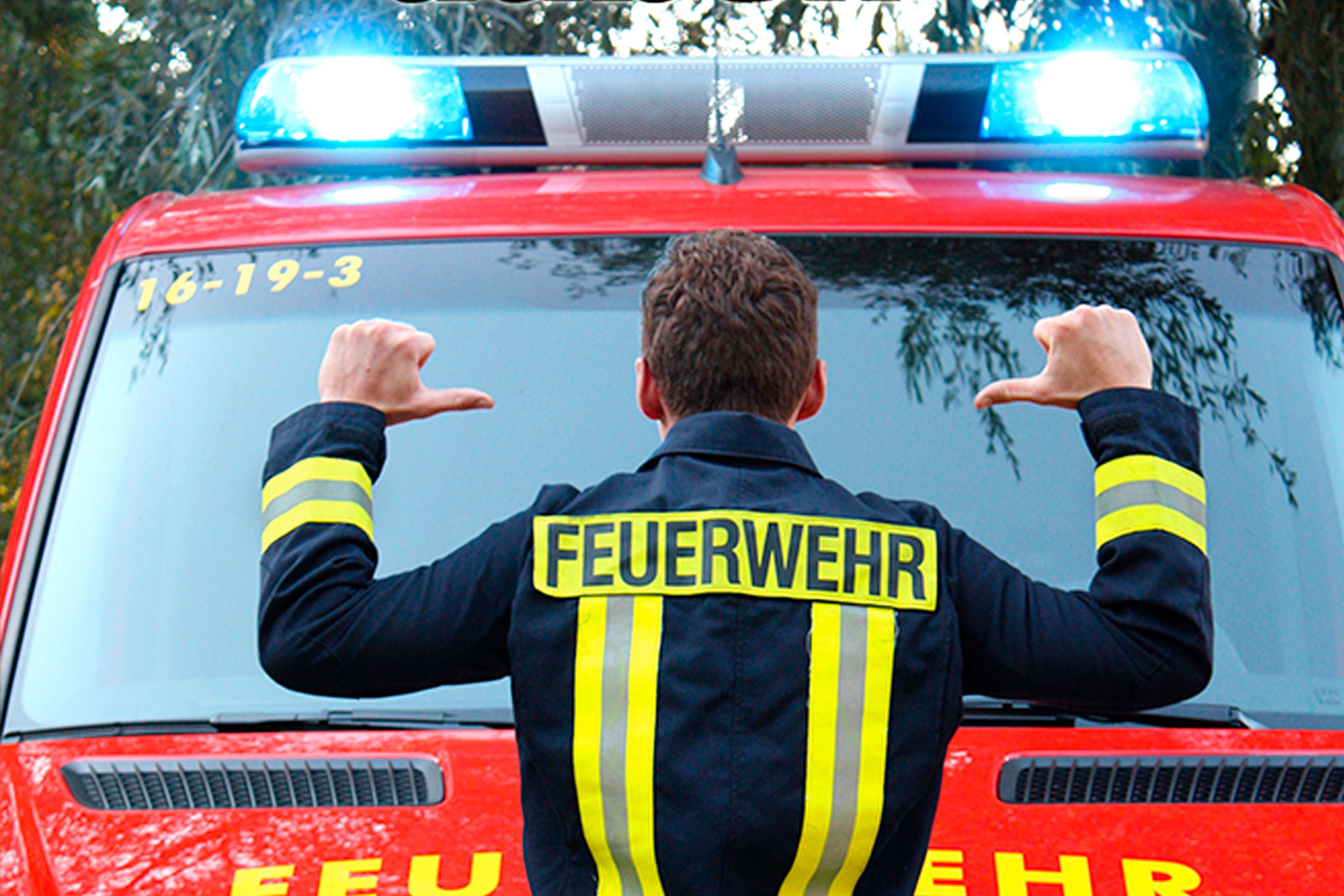 Ein Feuerwehrmann in Front eines Feuerwehrautos